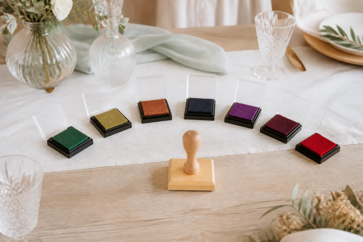 Encreurs colorés disposés autour d’une affiche d’arbre à empreintes sur une table en bois